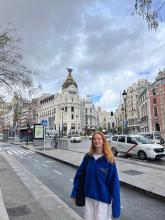 A young woman stands in a city square