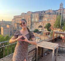 A young woman stands on a balcony in Siena, Italy