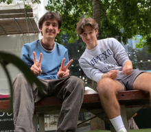 Two young men sit on a bench