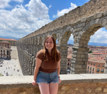 A young woman standing by arches in Segovia, Spain