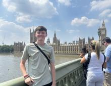 A young man stands in front of Parliament in London