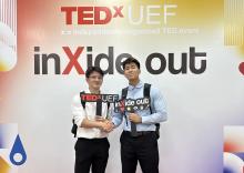 Two young men stand at a TED Talk event