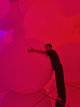 A young man hugs a circular sculpture