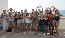 Large group of college students holding up the University of Oregon's hand sign, the letter "O." 