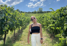 College-aged woman posing in a vineyard on a sunny day in Siena. 
