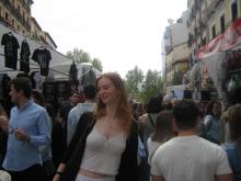 Smiling girl posing in the middle of a flea market in Madrid, Spain. 
