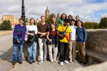 Group of college students posing on the sidewalk in Oviedo, Spain during their study abroad trip. 