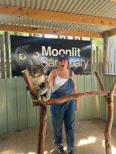 College students posing next to a koala at Moonlit Sanctuary in Melbourne, Australia. 
