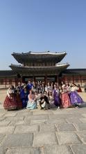  Group of people in traditional Korean hanbok dresses posing for a photo at Gyeongbokgung Palace in Seoul.