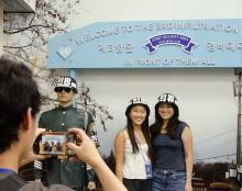 two people stand take a picture in front of a sign that reads "Welcome to the 3rd infiltration"