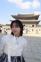 College student in traditional Korean dress in front of a temple in Seoul.