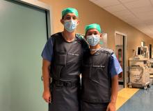Two student interns in hospital scrubs.