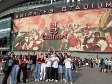 Group of people standing in front of Emirates Stadium
