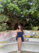 Lindsay sitting on a bench in a park