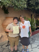 Will stands with a certificate next to someone else, they are both smiling