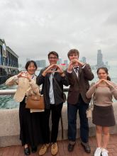 Kyler and three other students throwing their "O" on a cloudy day in Hong Kong, China.