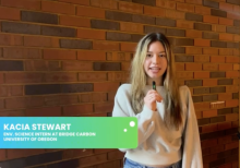 Kacia Stewart talking into a tiny mic in front of a brick wall in London