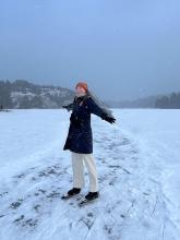 Annika with their arms out in the snow in Europe
