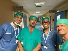 Densel smiling with three doctors in scrubs in an Italian hospital