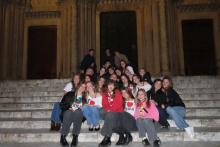 GEO students smiling for a photo on the steps of a church in Siena, Italy at night