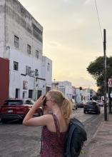A uo student taking a picture on a camera of the streets in Queretaro