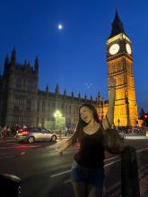 A night time scene at the big ben with a uo student standing in front