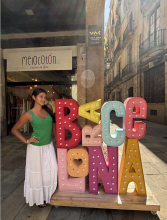 A uo student standing next to a Barcelona sign on the street