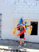 A uo student holding a piñata on the streets of Queretaro
