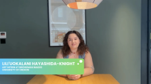 GlobalWorks intern sitting down at a table for an interview with a grey wall in the background