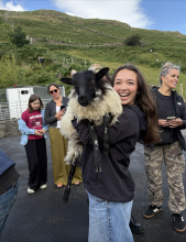 A uo student holding up a goat