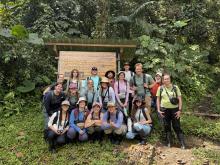 A group of UO students standing in front of a trail sign