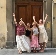 A group of UO students standing in front of a door with their hands in the air
