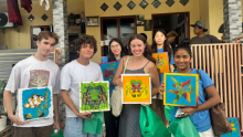 Six students holding paintings