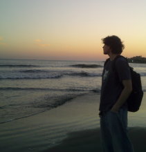 A person standing on the beach looking out at the sea