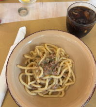 A bowl of pasta in a brown bowl