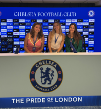 Three UO students sitting at a Chelsea London Football club desk