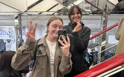 Zoe Tomlinson taking a mirror selfie with a friend on an escalator