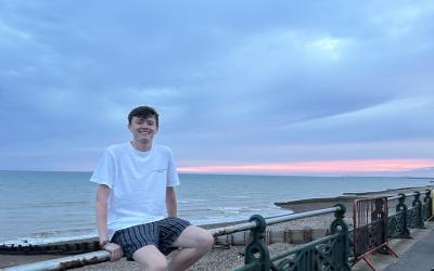 A young man sits by the Brighton coast