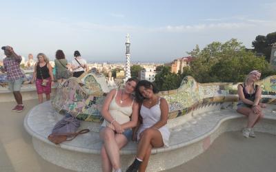 Two young women sit on a bench