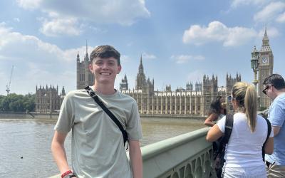 A young man stands in front of Parliament in London