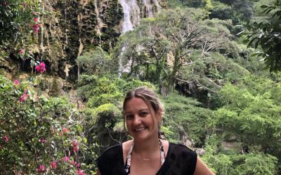 A woman stands by a waterfall in Mexico