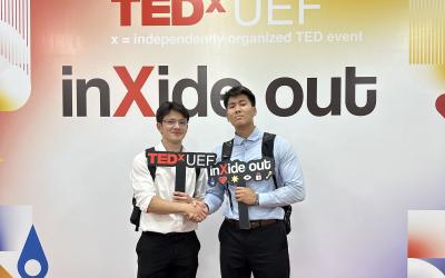 Two young men stand at a TED Talk event