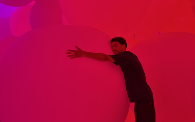 A young man hugs a circular sculpture