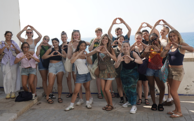 Large group of college students holding up the University of Oregon's hand sign, the letter "O." 