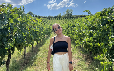 College-aged woman posing in a vineyard on a sunny day in Siena. 