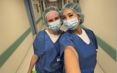 Two college-aged girls taking a .5 selfie in scrubs. 