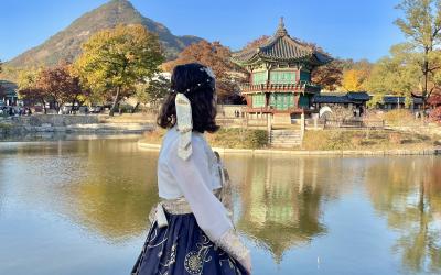 Young women looking at a temple in South Korea wearing a traditional dress. 