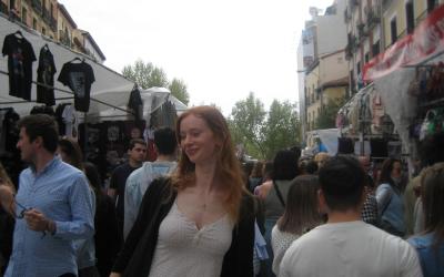 Smiling girl posing in the middle of a flea market in Madrid, Spain. 