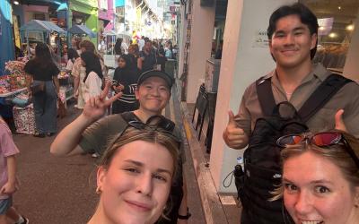 Logan and three friends stand with an alley, Haji Lane, behind them