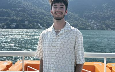 Luke stands on a boat at Lake Como